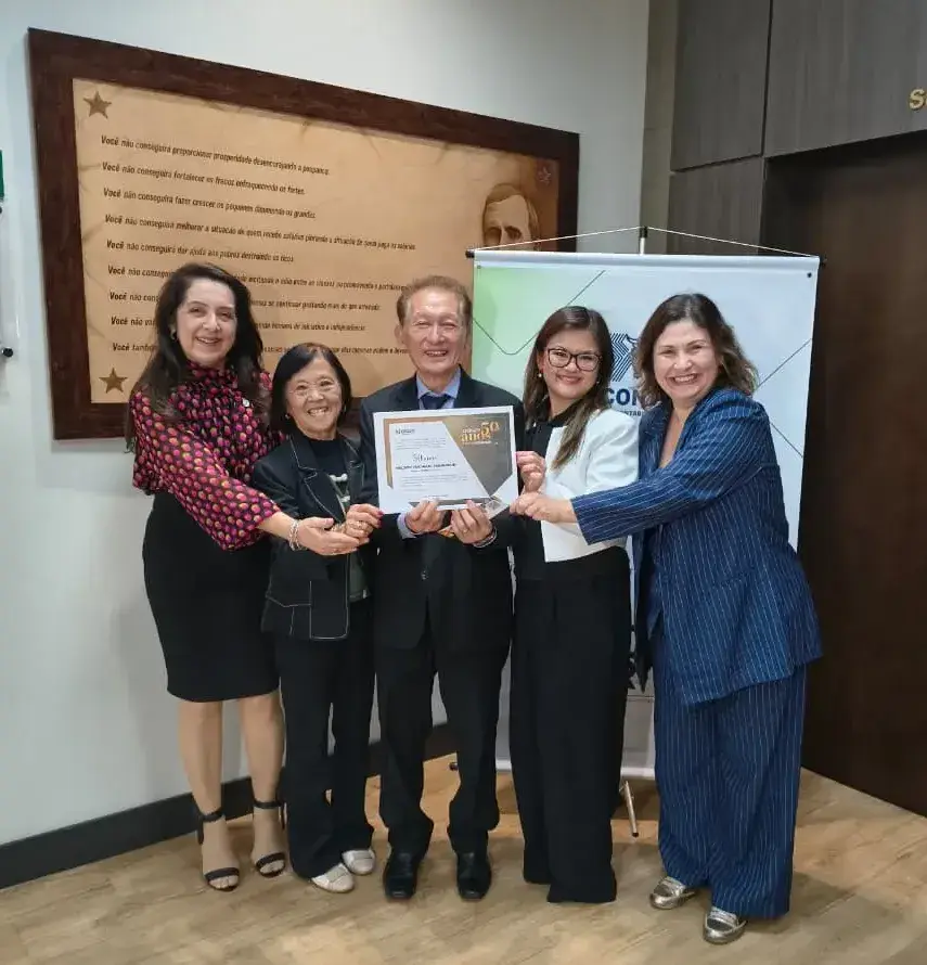 A vice-presidente de Desenvolvimento Profissional, Ariane Yumi, e a conselheira Miriam da Silva Braz, ao lado do homenageado e seus familiares