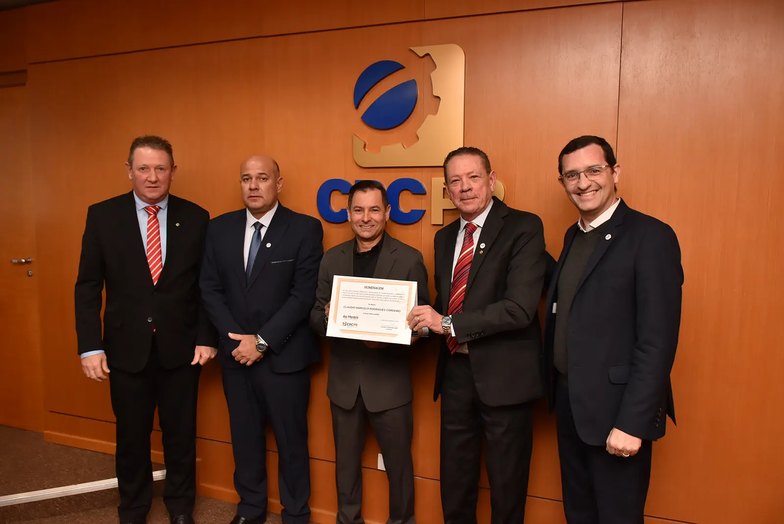 Cláudio Cordeiro durante homenagem “Ao Mestre, com Carinho”, realizada na manhã de quinta-feira (18), na sede do CRCPR, em Curitiba. À esquerda, Laudelino Jochem, vice-presidente de Desenvolvimento Profissional do CFC e Jefferson Paulo Martins, vice-presidente de Administração e Finanças do CRCPR. À direita, o presidente do CRCPR, Everson Breda Carlin, e o conselheiro Sérgio Porciúncula, todos professores.